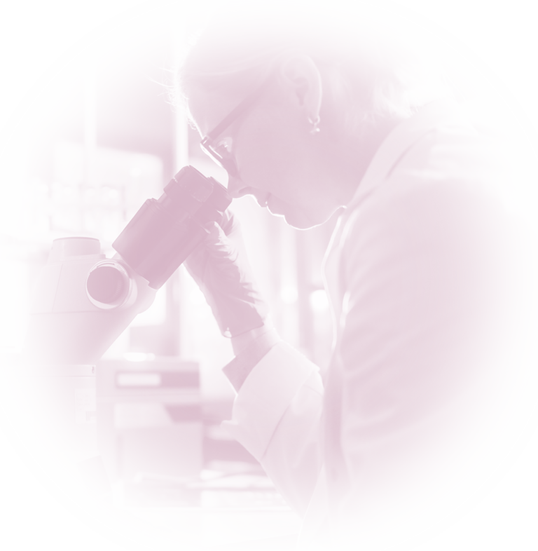 Servicios. Embrióloga en un laboratorio mirando por un microscopio.